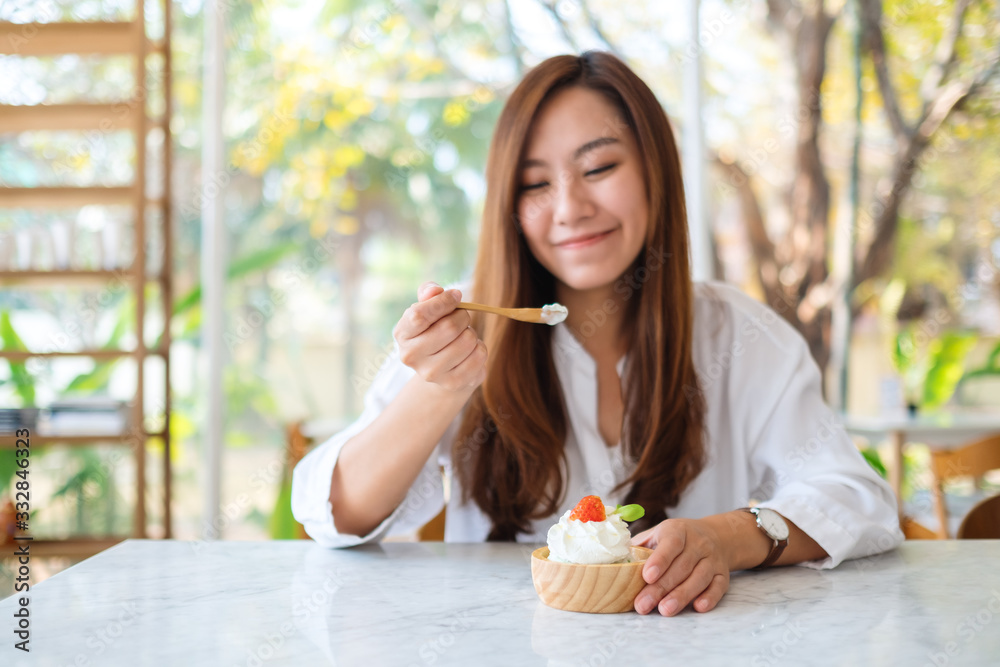 Closeup image of a beautiful asian woman enjoy eating an ice cream in restaurant Closeup image of a beautiful asian woman enjoy eating an ice cream in restaurant