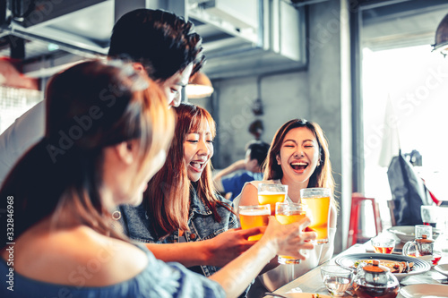 Sticker happy young friends dining and drinking beer at restaurant