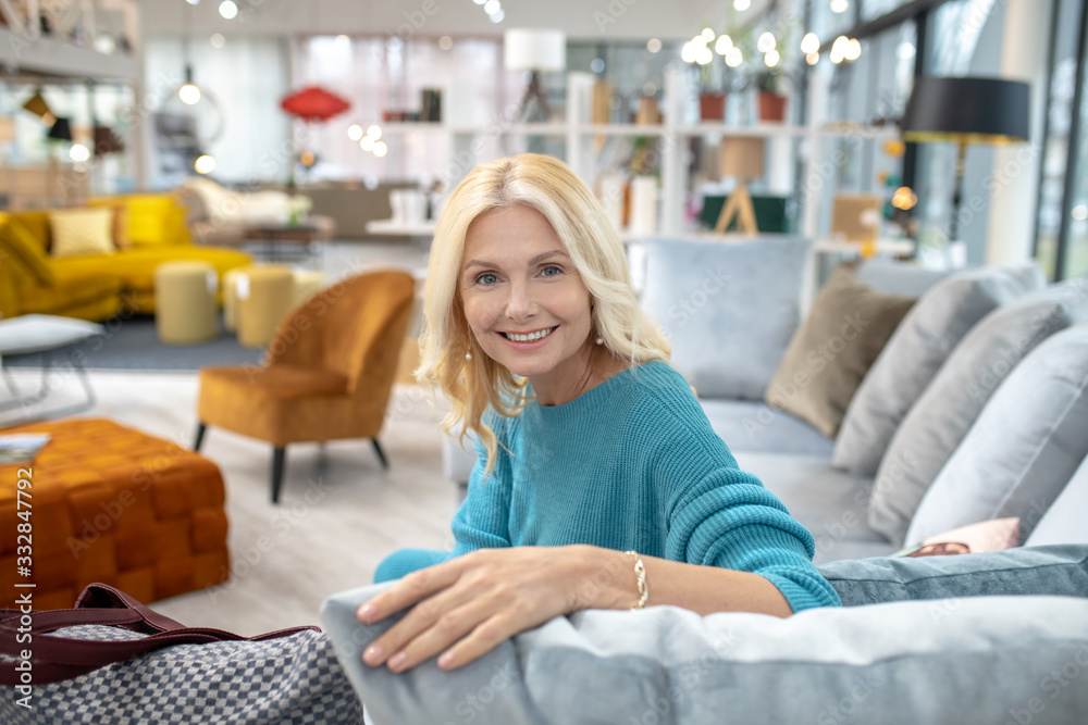 Woman sitting on a sofa in an exhibition furniture room. Woman sitting on a sofa in an exhibition furniture room.