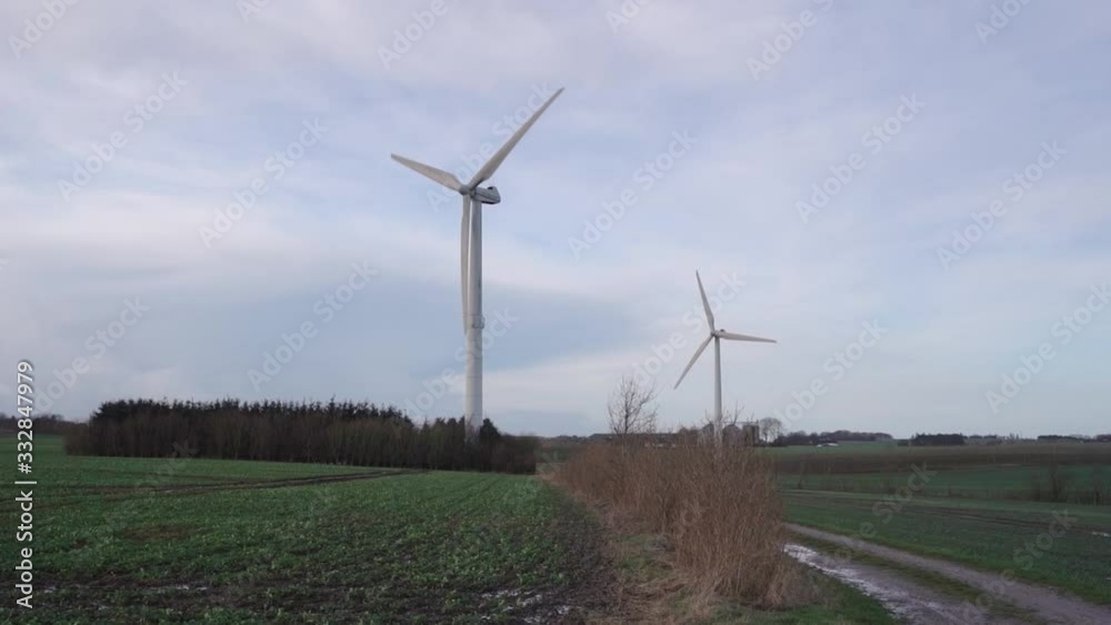 Windmill multiple wind turbines in rural background turning really fast Windmill multiple wind turbines in rural background turning really fast