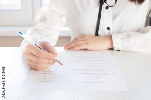 Drawing up a tax return. Hands holding a pen for signature