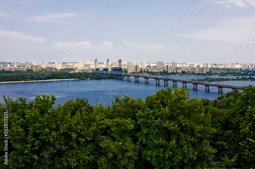 Forest, river, bridge, city in the distance under the sky