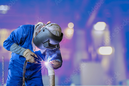 welder is welding by Tig torch, Industrial Worker laborer at the factory on bokeh background.