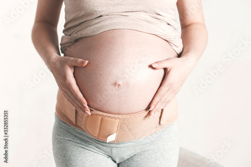 Image of pregnant woman touching her big belly. Close up. Motherhood, pregnancy, people and expectation concept. Pregnant woman expecting baby © Bugaev
