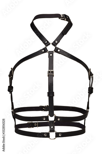 Subject shot of a simple black leather harness made of multirow straps with rivets, steel rings and buckles. The chest harness is isolated on the white background. 