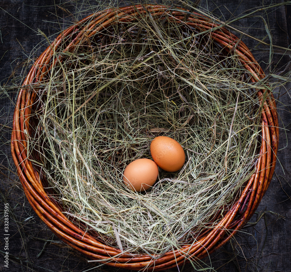 Two chicken egg in a straw nest for Easter, rustic style, table, top view, copy space left Two chicken egg in a straw nest for Easter, rustic style, table, top view, copy space left