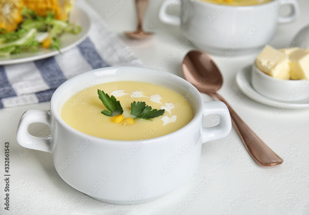 Delicious corn cream soup served on white table Delicious corn cream soup served on white table