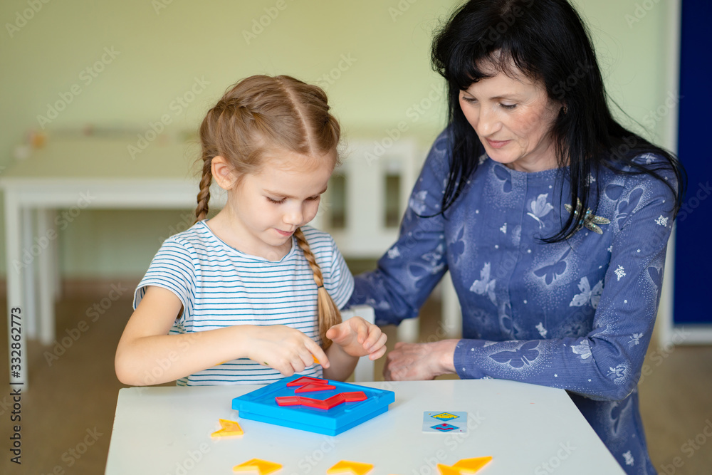 a teacher and girl solve mathematical puzzle. a teacher and girl solve mathematical puzzle.