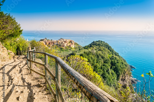 Corniglia, Cinque Terre - hiking trail near beautiful village with colorful buildings on the cliff over sea. Cinque Terre National Park with rugged coastline is famous tourist destination in Italy photo