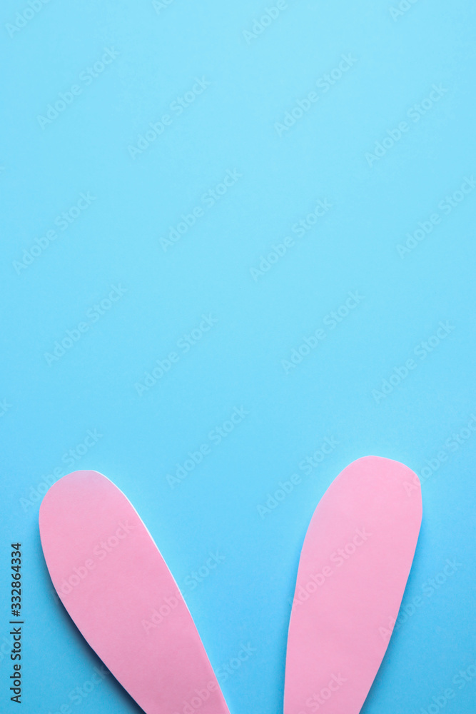 Top view of paper bunny ears on blue background, space for text. Easter celebration