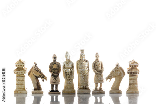 A view of several white chess pieces. Ceramic chess pieces against white color background