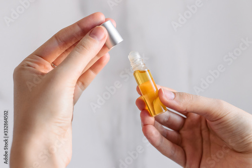 Bild auf Leinwand Oil aromatic perfumes made of natural essential oils on a bright white marble background in hand
