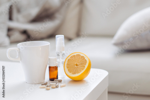 Remedies for the disease on the home table. A cup of tea, essential oil, lemon, pills and medication. Bed rest. Virus, cold, cough, cold, bacterial.