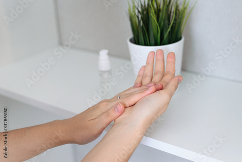 Application of antibacterial agent - antiseptic - with aloe vera gel  alcohol and essential oils on hands. Close up. Skin care serum. Natural leaving. Virus Prevention and treatment.