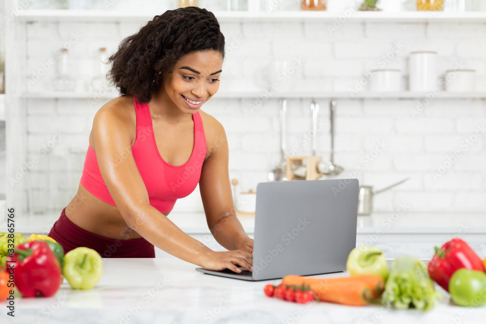 Black girl using laptop searching new recipes Black girl using laptop searching new recipes