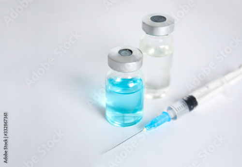 Vials and syringe on light background. Vaccination and immunization