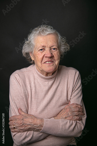 Cheerful portrait of a grandmother. The concept of seniority and the elderly. Model grandmother in the studio on a black background. © M.V.schiuma