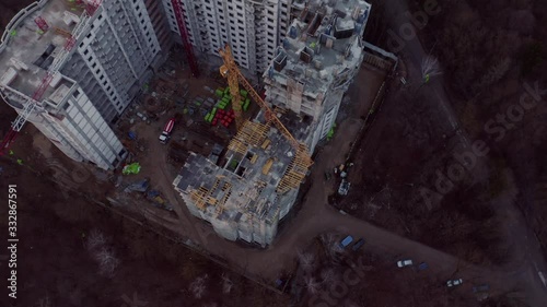 Top view of flight over construction of house on sunset. Crane and construction processes.