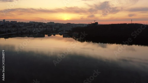 Top view of flight over lake at sunset. Landscape, reflection in the water. Fast.