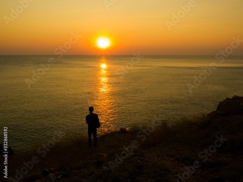 Silhouettle of man.He watching seaview and sunset on the hill.