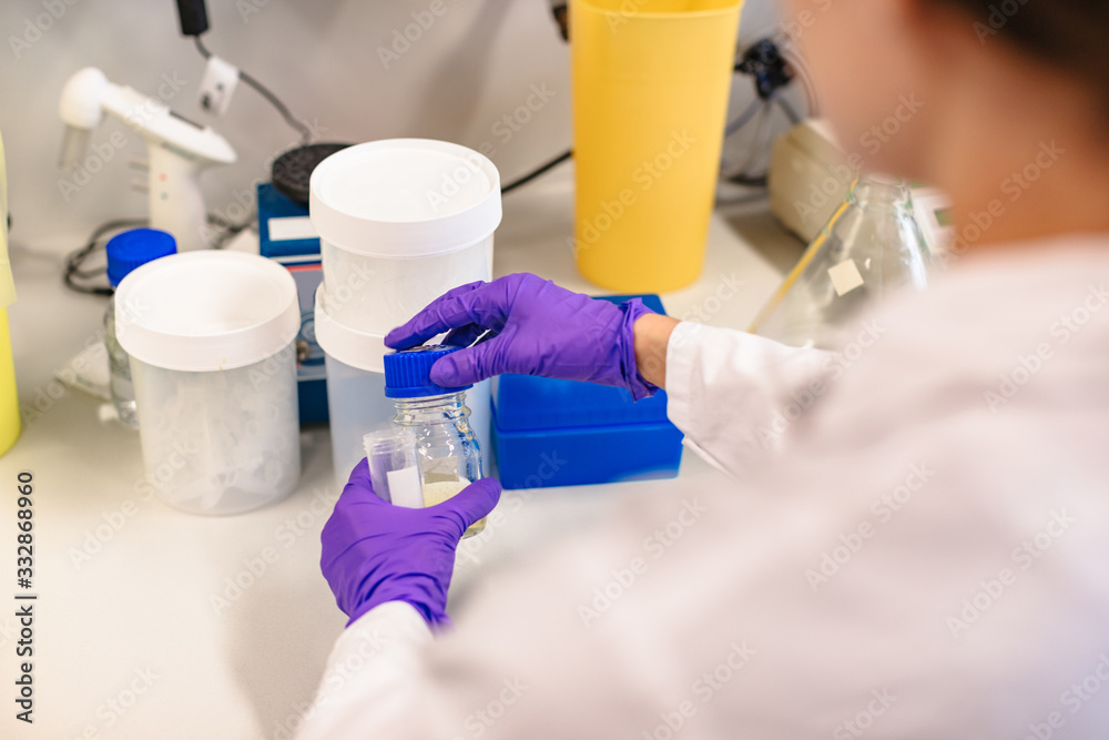 Obraz premium Scientist holding flask in front experiment boxes