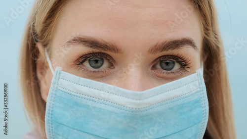 Close-up portrait woman blonde medical mask her face fluttering in wind during quarantine Coronavirus COVID-19 virus looks distance anxiously frowning forehead. Epidemic, pneumonia, hygiene. Pandemic