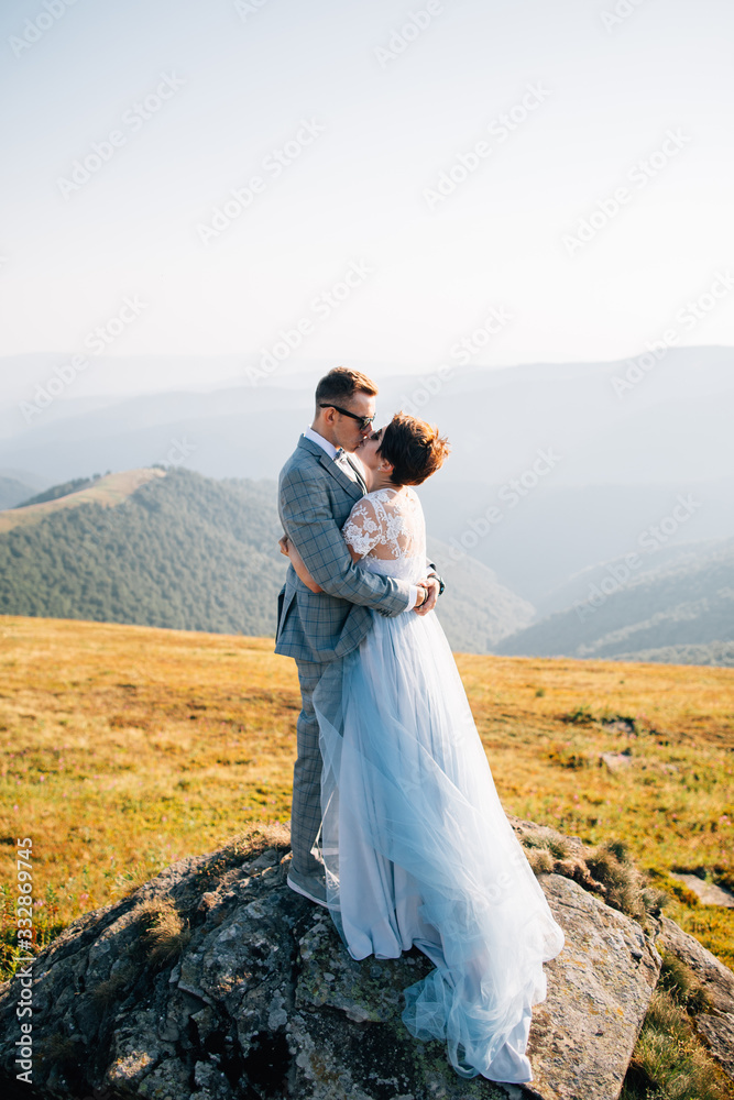 Outdoor wedding inspiration. Newlyweds hugging in moutains.