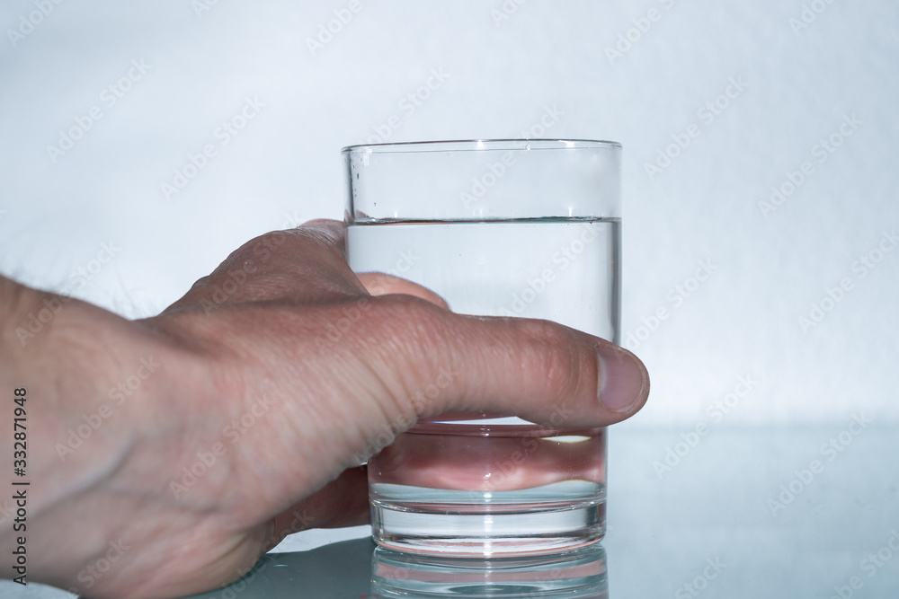 Wasserglas mit frischem Mineralwasser in der Hand halten - Wasser trinken als erfrischung Wasserglas mit frischem Mineralwasser in der Hand halten - Wasser trinken als erfrischung