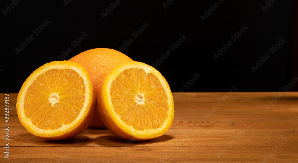 Halves oranges on a black background. Space for text. Sliced citrus fruits on a wooden table. Halves oranges on a black background. Space for text. Sliced citrus fruits on a wooden table.