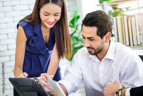 Business woman presenting and discussing financial data and analyzing report graph by digital tablet at office. Teamwork meeting and partnership conference working concept.