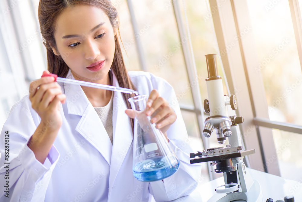 Attractive young Asian scientist woman lab technician assistant analyzing sample in test tube at laboratory. Medical, pharmaceutical and scientific research and development concept. Attractive young Asian scientist woman lab technician assistant analyzing sample in test tube at laboratory. Medical, pharmaceutical and scientific research and development concept.