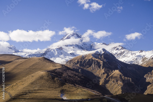 Kazbegi Mountain in Georgia - with some clouds on it and snow.