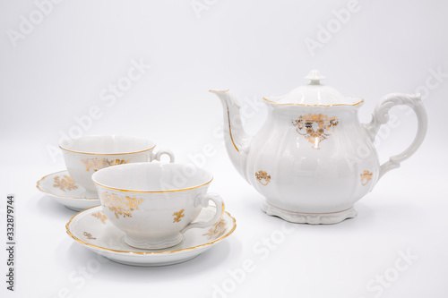 Obraz na płótnie Vintage white teapot with tea cups with golden design in classic style isolated on white background w salonie