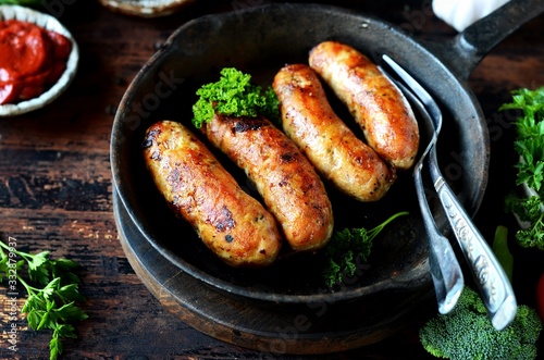 Homemade chicken (turkey) sausages fried in a pan. picnic. rustic