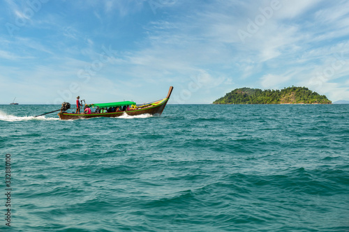 Traditional wooden boat sail on the sea tropical bay to diving at small island, Ranong Province, Thailand, Asia. photo