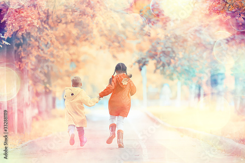 children run in the yellow autumn park rain / fun walk autumn seasonal landscape weather wet