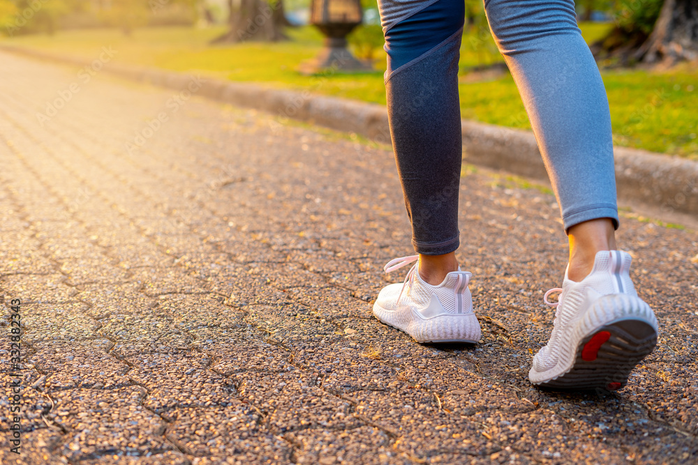 young woman runner running at road with orange light 