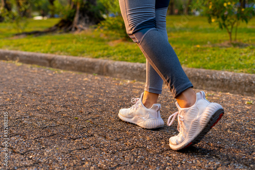Young woman walking exercise on a brown street with white shoes exercising photo