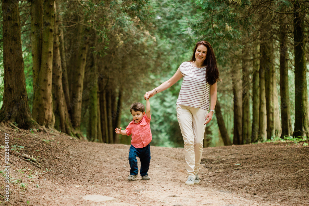 Mother having fun with cute son in summer park. Happy woman with cheerful little boy outdoors Mother having fun with cute son in summer park. Happy woman with cheerful little boy outdoors