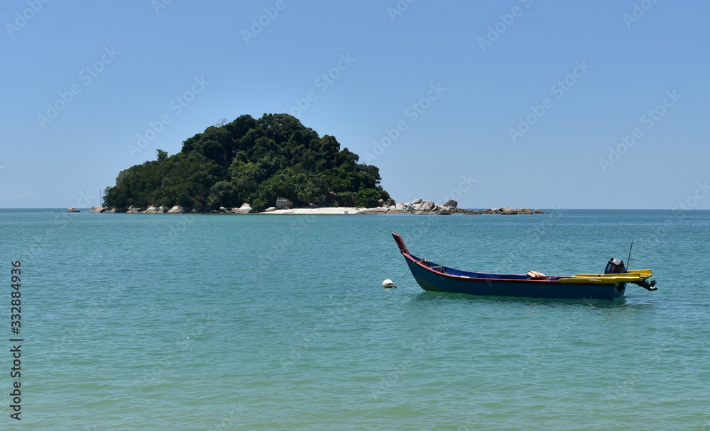 Colorful boat in front of a tropical island in Malaysia Colorful boat in front of a tropical island in Malaysia
