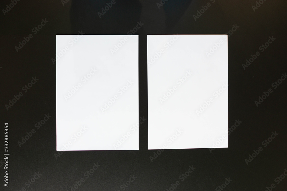 Two Stacks of Blank Paper Lying Symmetrical on Black Desk Two Stacks of Blank Paper Lying Symmetrical on Black Desk