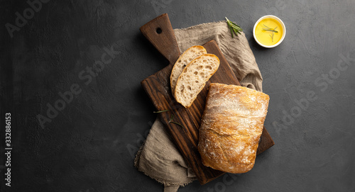 Quadro em tela Crispy italian ciabatta bread on black background