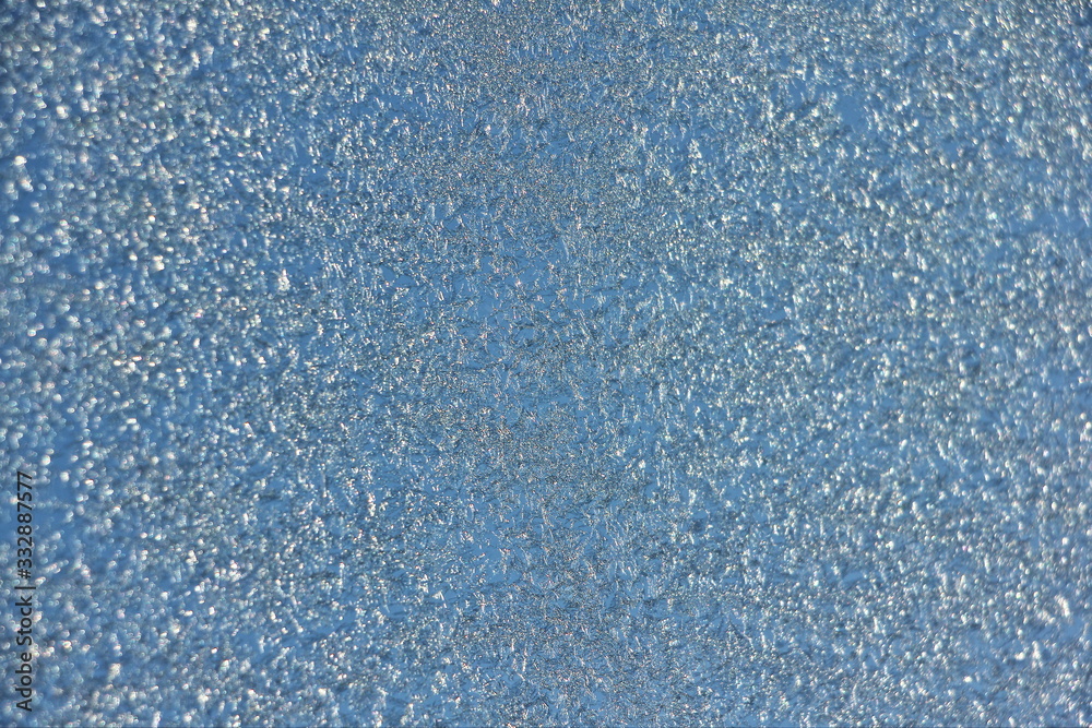 Blue hoarfrost background texture on glass on sky backdrop