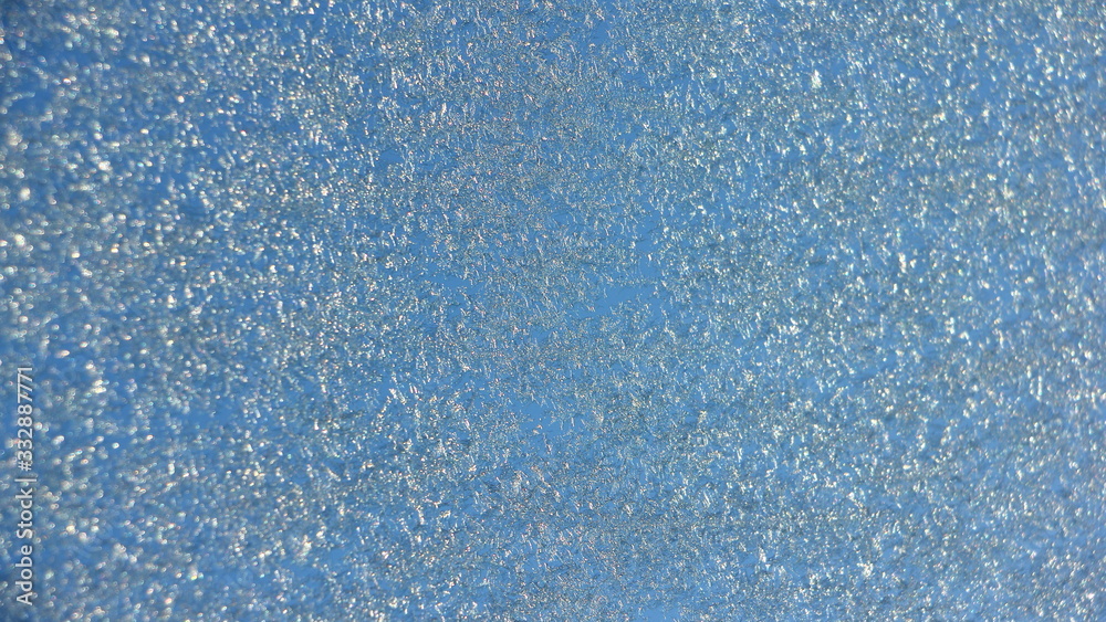 Fototapeta premium Blue hoarfrost on glass background texture