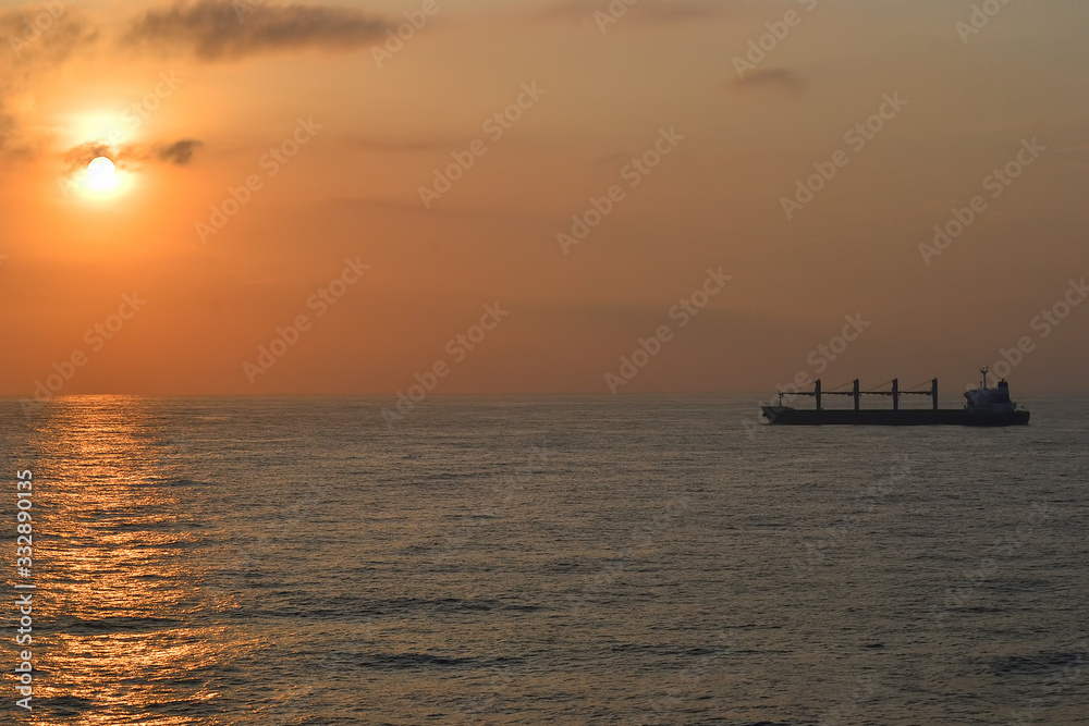 cargo ship on the ocean at sunset for logistics international transport