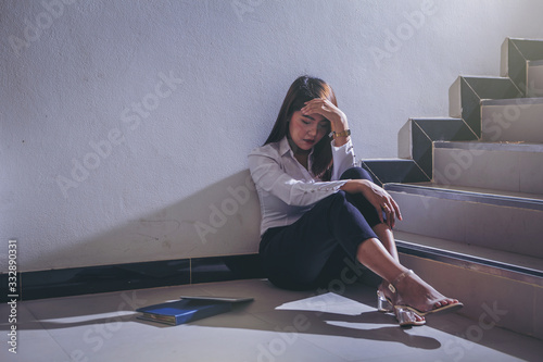 Bad investment or economic crisis concept. Hopeless businesswoman is disappointed and seriously sitting down at stairway. photo