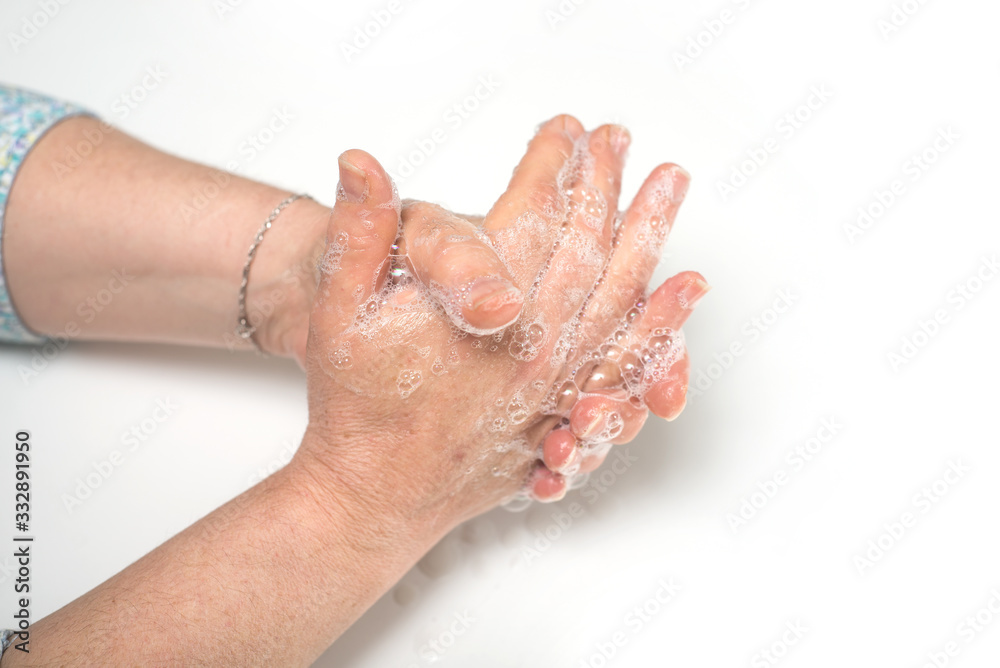 Closeup of hands of woman whashing hands on white background to protect against the coronavirus Closeup of hands of woman whashing hands on white background to protect against the coronavirus