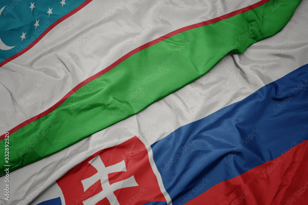 waving colorful flag of slovakia and national flag of uzbekistan.