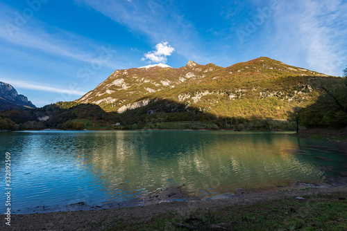 Lago di Tenno, small Alpine lake in Trentino-Alto Adige, with mountains in autumn (Monte Misone). Trento province, Italy, Europe