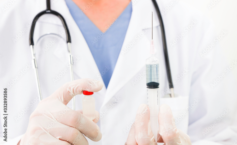 Selective focus of Doctor which his Hand holding syringe and vaccine,corona virus concept Selective focus of Doctor which his Hand holding syringe and vaccine,corona virus concept